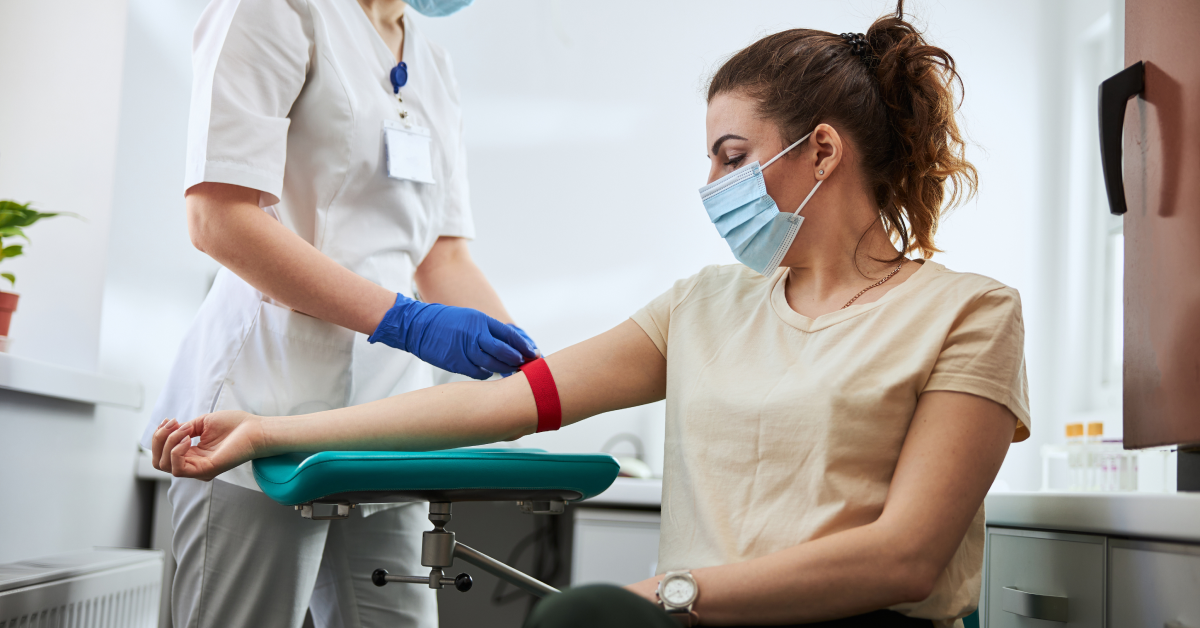 Medical technician administering a blood draw on a patient