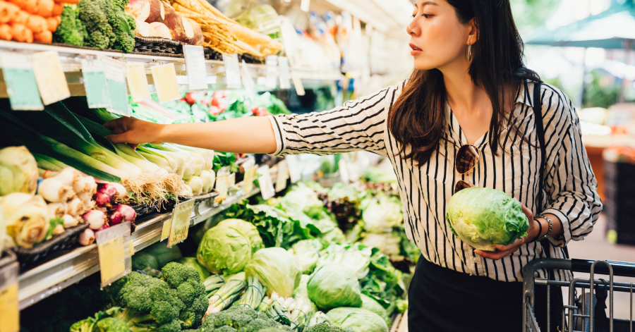 Woman with food basket at grocery or supermarket